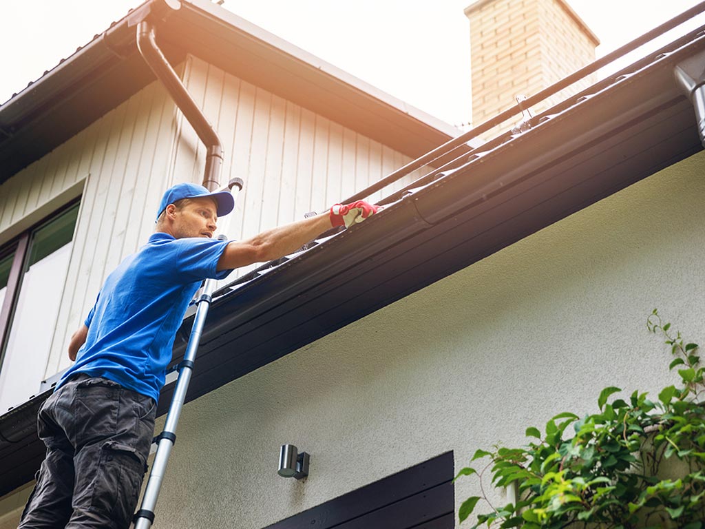 man cleaning roof manually